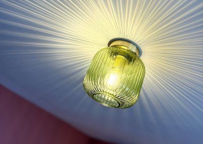 Green ribbed glass ceiling light throwing a starburst across the ceiling