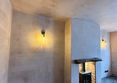 Wall lights fitted either side of a chimney breast in a newly plastered room